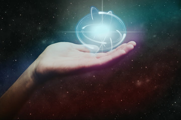 Human hand holding atom. Nebula dust. Mixed media.