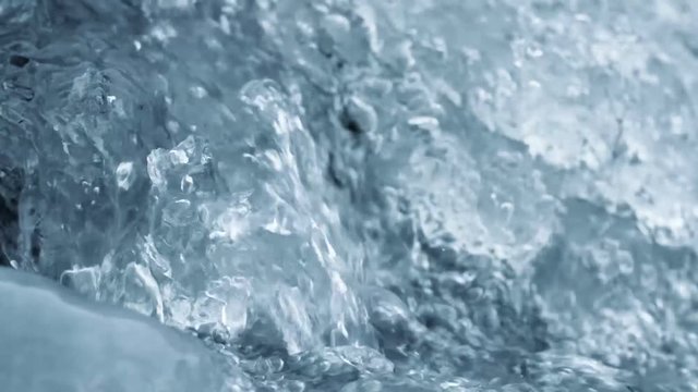 Crystal water with air bubbles and ice. Close up slow motion nature background footage.