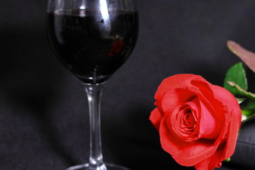 赤い薔薇の花と赤ワインのグラス(黒背景)
