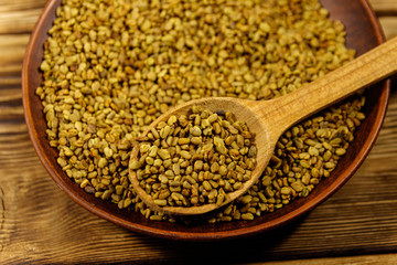 Fenugreek seeds in ceramic plate on wooden table