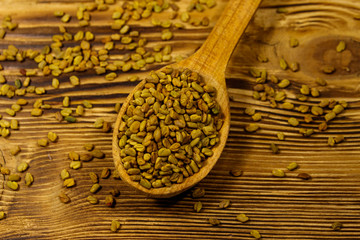 Fenugreek seeds in wooden spoon on wooden table