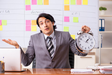 Young handsome employee working in the office