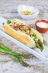 Hot Dog mit grünem Spargel und Schinken