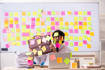 Young employee in conflicting priorities concept 