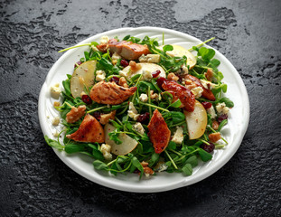 Pear, chicken salad with blue cheese, cranberry and walnuts. concept healthy food. black background