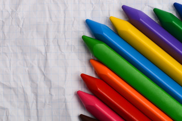 Colored pencils on a piece of paper with free space for text.