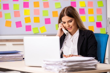 Young beautiful businesslady in conflicting priorities concept 