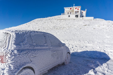Winter landscape of the shelter of Velouchi mountain in Karpenissi, Evritania, Greece. A frozen car outside the shelter