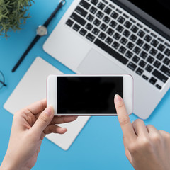 Social network connecting office table concept with fashion accessories, minimal interior with a woman holding smartphone, top view, flat lay, mockup, copy space