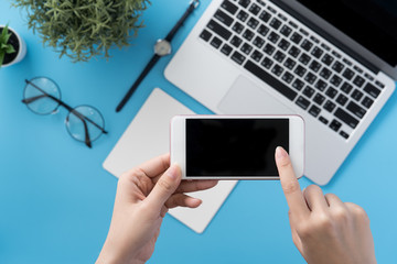 Social network connecting office table concept with fashion accessories, minimal interior with a woman holding smartphone, top view, flat lay, mockup, copy space