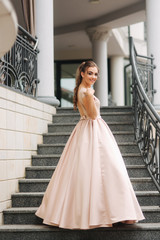 Elegant lady satnd on stairs in front of restaurant