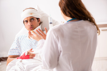 Young doctor examining injured patient 