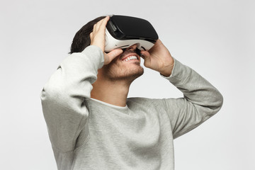 European Caucasian male wearing virtual reality headset having great fun while gaming