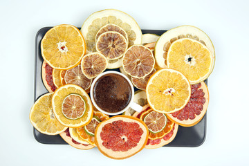 Black coffee in a white Cup surrounded by citrus dried fruits