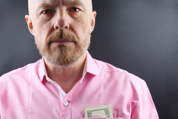 Bearded man in a pink shirt  money in his pocket