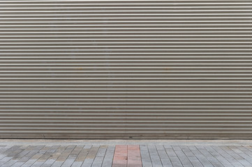A closeup shot of automatic metal roller door used in factory, storage, garage, and industrial warehouse. The corrugated and foldable metal sheet offer space saving and provide urban and rustic feel