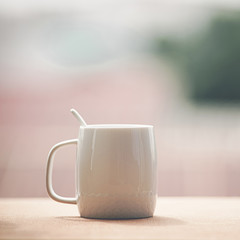 Cup of morning coffee on wooden table at balcony. Coffee mug.