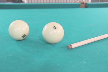 Balls and a cue for Russian Billiards on a billiard table with a green cloth