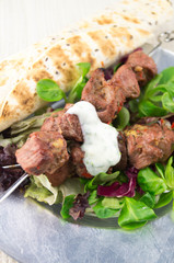 Gegrillte Fleischspieße mit Salat und Brot