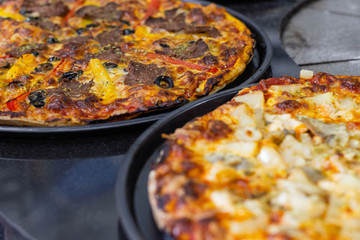hot tasty delicious rustic homemade american pizza with tomato with thick crust on black table