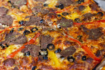 hot tasty delicious rustic homemade american pizza with tomato with thick crust on black table