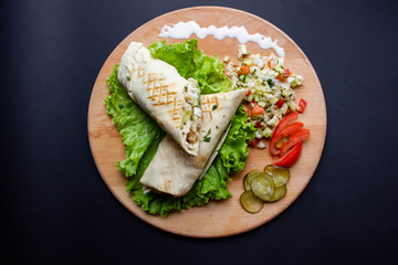 Shawarma sandwich with ingredients on dark background. Top view. sandwich in pita bread. burrito