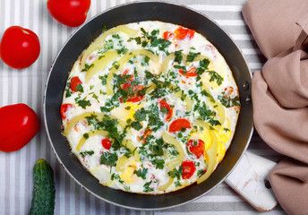 Traditional rustic omelette with bacon, pasta and greens .  Copy space