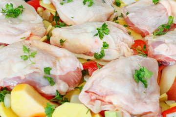 Delicious raw chicken with fresh vegetables, fruits and spices