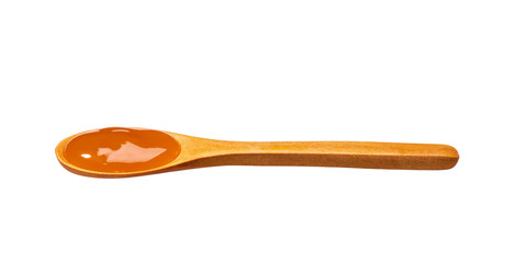 Orange sweet and sour sauce in small wooden spoon isolated on white background,