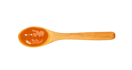 Orange sweet and sour sauce in small wooden spoon isolated on white background,top view