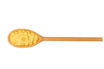 Mustard sauce in small wooden spoon isolated on white background,top view
