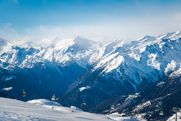 Fototapeta na wymiar Alpine landscape in the Italian Alps. Snowy mountains and ski lifts