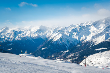 Fototapeta na wymiar Alpine landscape in the Italian Alps. Snowy mountains and ski lifts