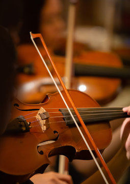 Closeup of the musician's hand is playing a violin in an orchestra.