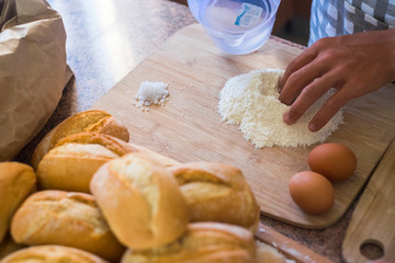 closeup in the kitchen with caucasian woman hand working and preparing cake or bakery at home with farina eggs and water for easy cook to made fresh food