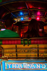 Naklejka premium TukTuk taxi car with passengers at night time in Bangkok, Thailand