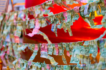 Fototapeta premium Banknotes sacrificed to Thai Angel in Bangkok, Thailand