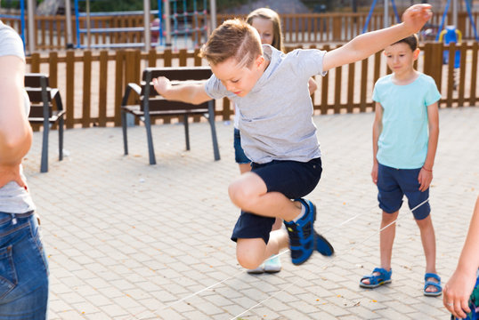 Happy children skipping on jumping elastic rope