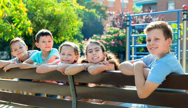 Five children sitting on a bench at the playground