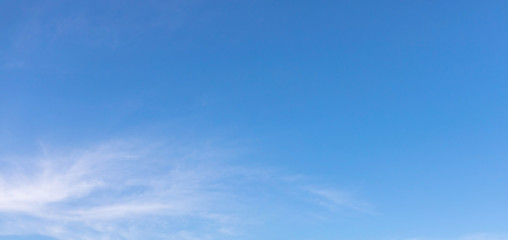 Thin white clouds are floating in the clear blue sky