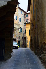 Narrow street in old italian town with parked old car