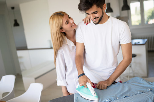 Girl Bothering Boyfriend While Ironing Shirt