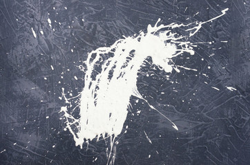 a spot of white spilled paint on a concrete textured surface
