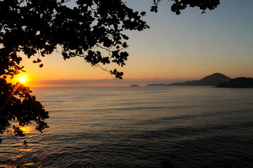 Fototapeta na wymiar Sunrise, Ubatuba, Sao Paulo, Brazil - Paradise tropical beach with white sand, blue and calm waters, without people on a sunny day and blue sky of the Brazilian coast in high resolution