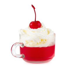 Strawberry jelly in a glass with cherries and whipped cream isolated on white background