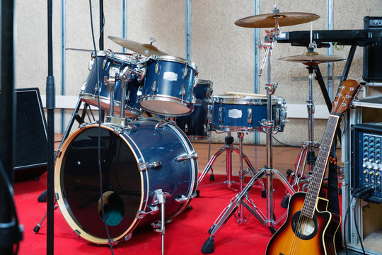 Set of musical instruments ready for rehearsal of music band in modern sound studio