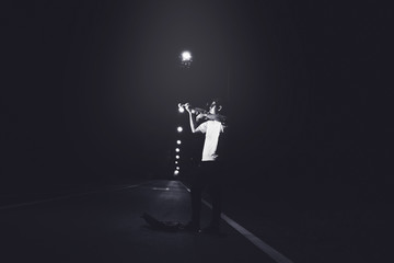 young man playing violin in the dark on street, journey of musician concept