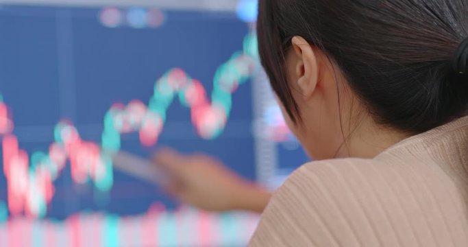 Woman check on the stock market data at the computer