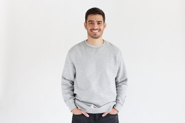 Daylight portrait of young handsome man, wearing oversized sweatshirt, isolated on gray background - Powered by Adobe