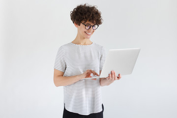 Portrait of young woman holding laptop and watching media with happy smile, sharing web content